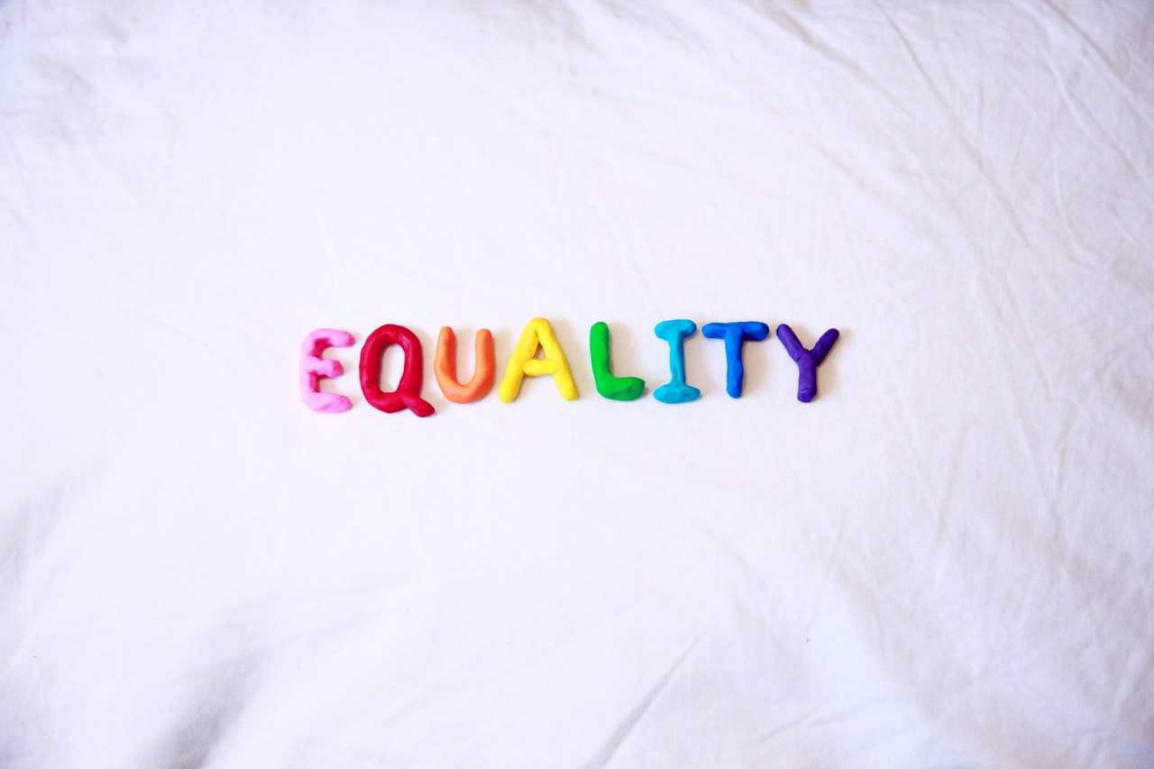 Auf einem weißen Hintergrund steht das Wort Equality ( auf Deutsch "Gleichheit"). Das Wort ist in Regenbogenfarben geschrieben.