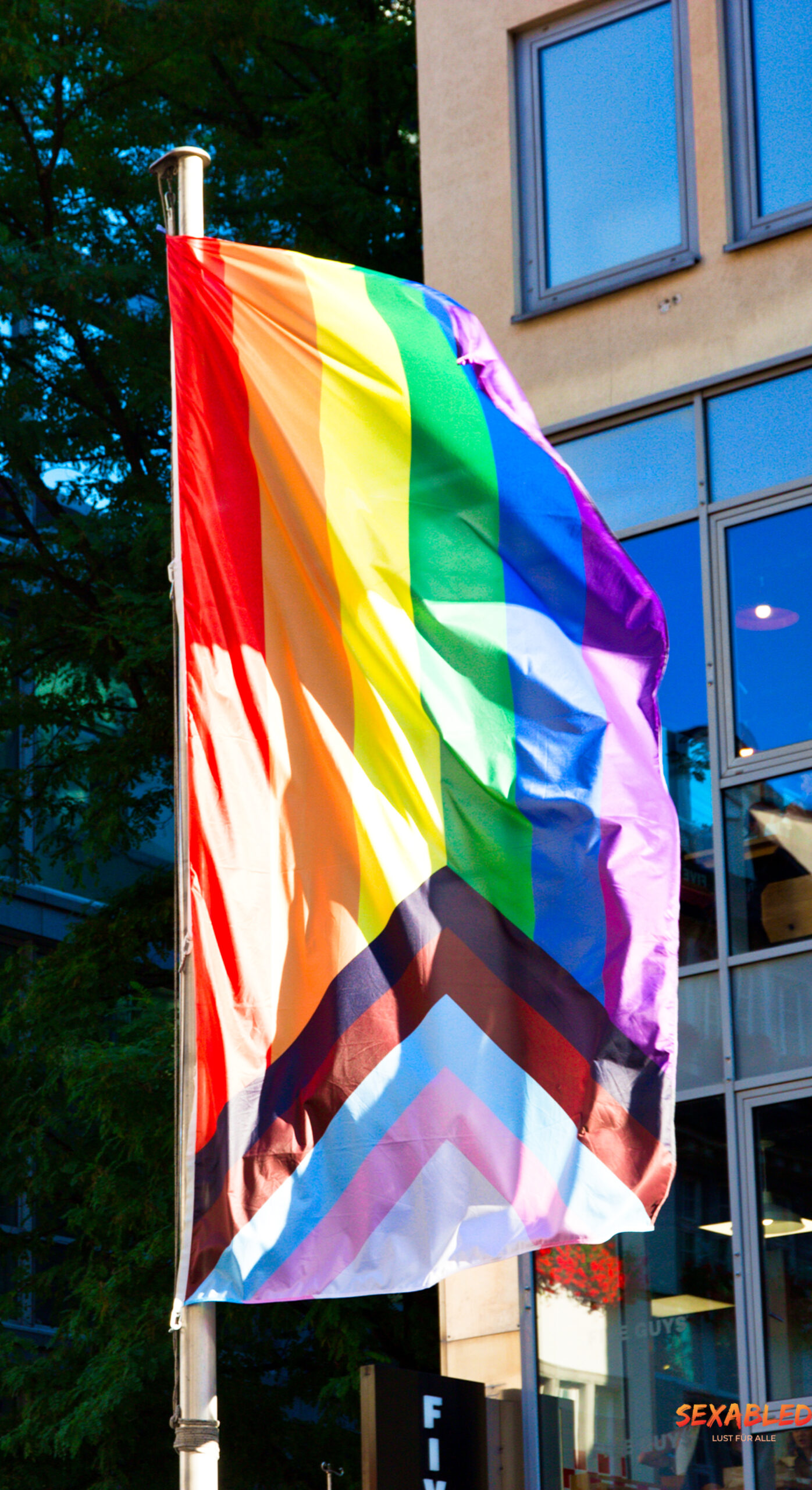 Das Bild zeigt eine wehende Progress Pride flag auf dem CSD in München.