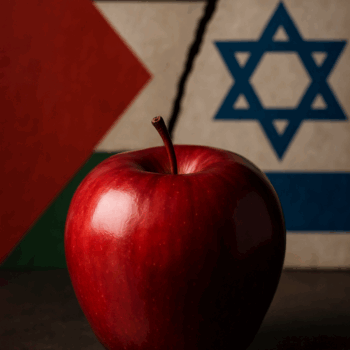 Ein glänzender, roter Apfel steht im Vordergrund auf einer dunklen Fläche. Dahinter ist eine Wand mit zwei Flaggen zu sehen: links die palästinensische, rechts die israelische. Beide sind durch einen dunklen, schrägen Riss getrennt, der den Kontrast zwischen ihnen betont. Dezentes Licht hebt die glatte Oberfläche des Apfels hervor.